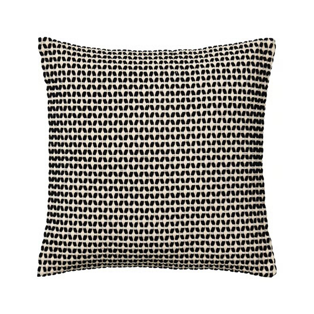 Esta funda de cojín tiene una base beis sobre la que se ha bordado un motivo con hilo negro que crea una discreta y característica textura. 
