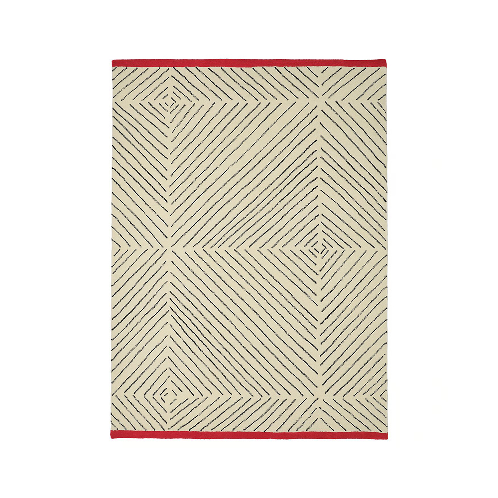 Las líneas hechas mano mediante la técnica de tufting forman un motivo romboidal que acaba en los extremos con bordes en rojo intenso